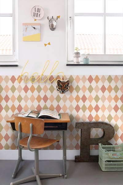 Dekoratives Kinderzimmer mit Schreibtisch, Stuhl und Rautenmuster-Tapete.