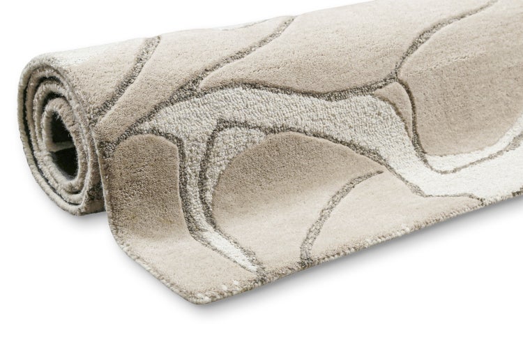 Eingerollter Teppich mit Wellenmuster und strukturierter Oberfläche.