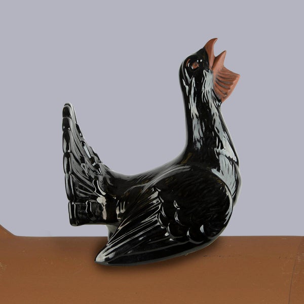 Schwarze Dachfigur Auerhahn aus glasiertem Ton, dekorativer Firstschmuck für das Hausdach.