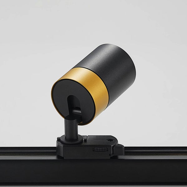 Moderner zylindrischer Strahler für Schienensystem, Schwarz mit goldfarbenem Zierring.