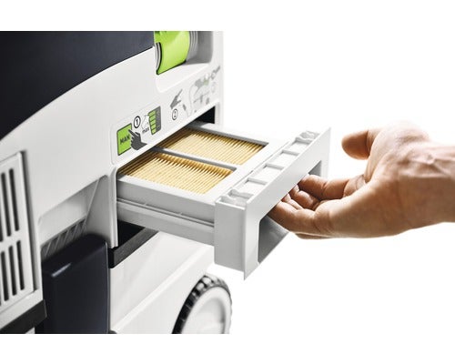 Eine Hand zieht das Filterfach eines Absaugmobils mit einem Lamellenfilter heraus.
