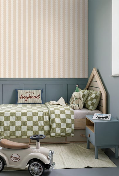 Kinderzimmer mit Tapete mit vertikalen Wellenstreifen, einem Hausbett aus Holz und halbhohen Wandpaneelen.