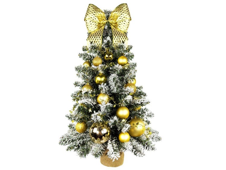 Künstlicher Weihnachtsbaum mit Schnee, geschmückt mit goldenen Kugeln und einer großen Schleife an der Spitze, in einem Jutesack stehend.