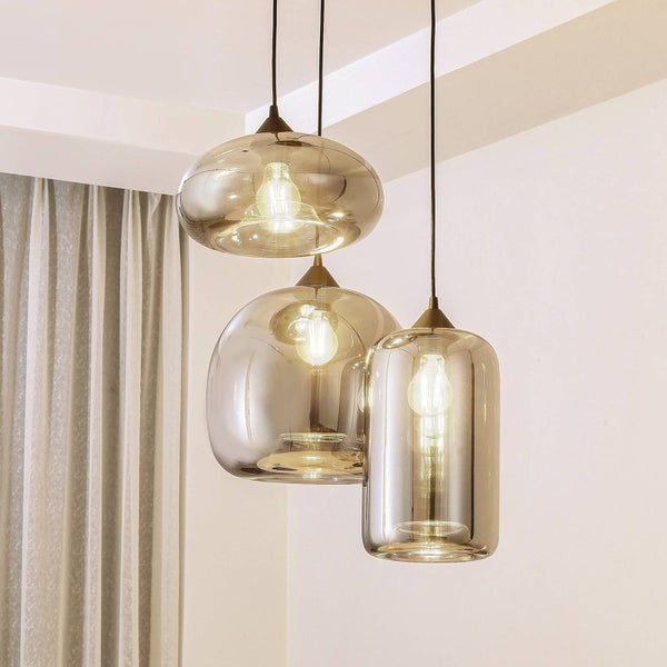 Dreiflammige Pendelleuchte mit Glasschirmen in verschiedenen organischen Formen, inklusive sichtbarer Leuchtmittel, modernes Design.