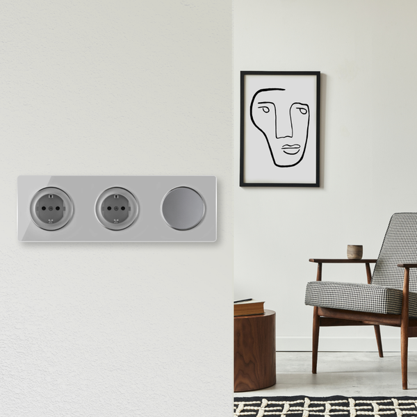 Moderne Steckdosenkombination mit Drehdimmer in einem Wohnzimmer mit Sessel und abstraktem Bild an der Wand.