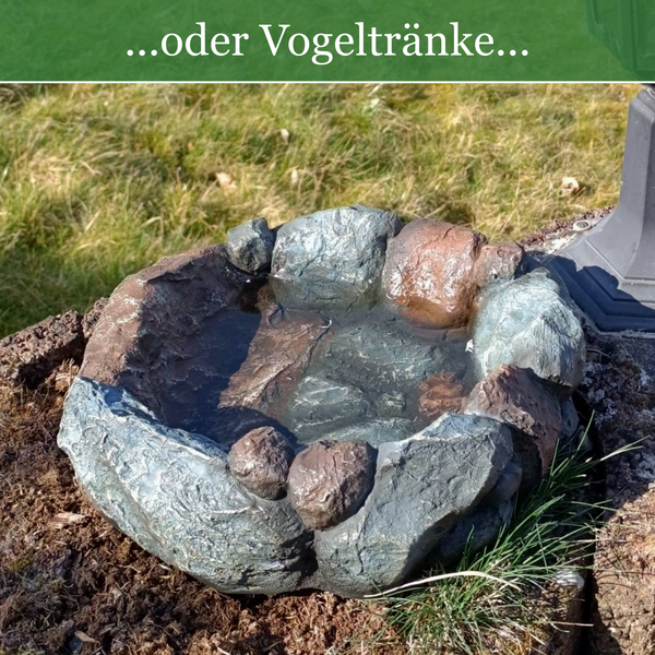Vogeltränke in Steinoptik im Garten gefüllt mit Wasser.