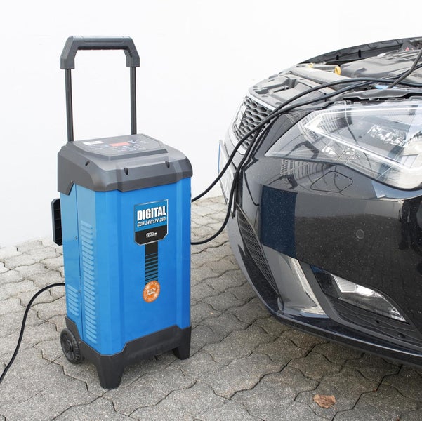 Guede Batterieladegerät GDB 24V 12V 200 an einem Auto angeschlossen auf gepflastertem Untergrund