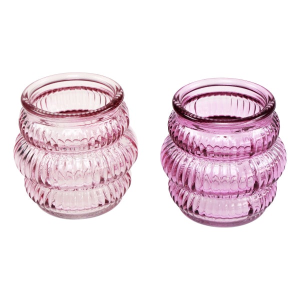 Zwei geriffelte Teelichthalter aus violettem Glas.