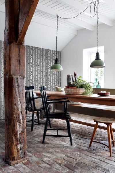 Esszimmer mit Holztisch, Stühlen und Birkenmuster-Tapete