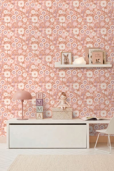 Tapete mit Blumenmuster im Kinderzimmer mit einem niedrigen Schrank, einem Wandregal mit Büchern, einer Schreibtischlampe und einem Stuhl.
