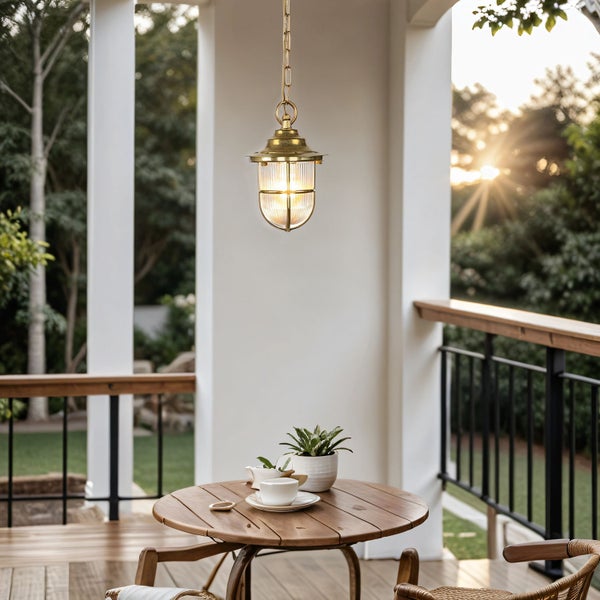 Hängelampe über einem Holztisch auf einer Veranda mit Blick auf einen Garten.