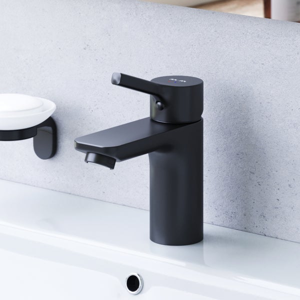 Moderne Einhebel Waschtischarmatur in matter Optik montiert auf einem Waschbecken vor einer grauen Wand mit Seifenschale.