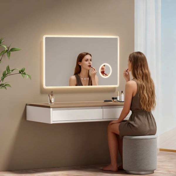 Moderner rechteckiger Badezimmerspiegel mit LED-Beleuchtung, Digitaluhr und Kosmetikspiegel in einer hellen Schminkecke.