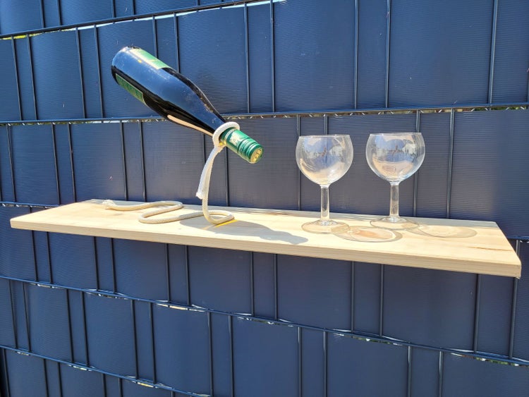 Weinregal mit einer Flasche Wein und zwei Gläsern