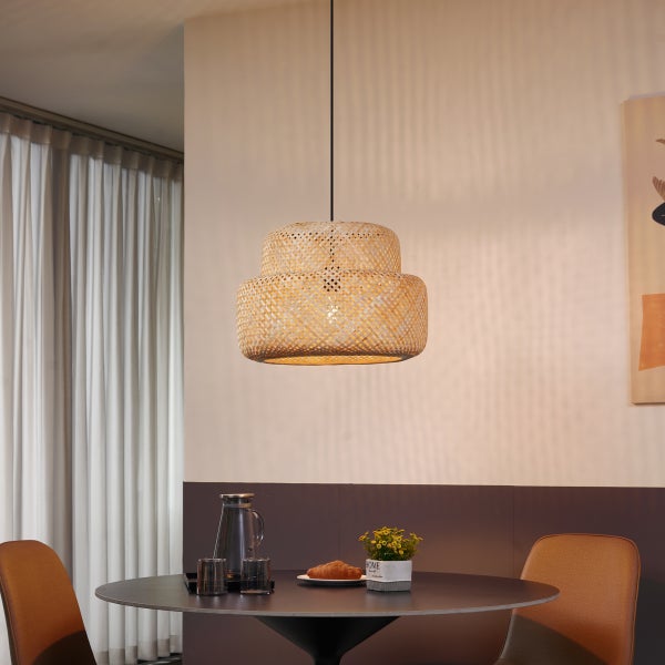 Zweischichtige Hängeleuchte aus Rattan über einem Esstisch