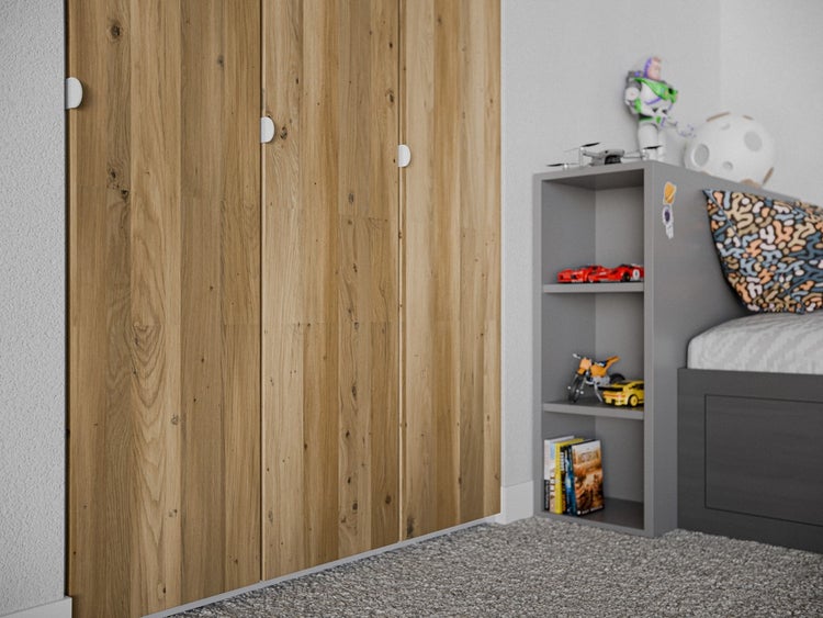 Dreitüriger Kleiderschrank in Eichenoptik in einem hellen Kinderzimmer neben einem grauen Regalbett.