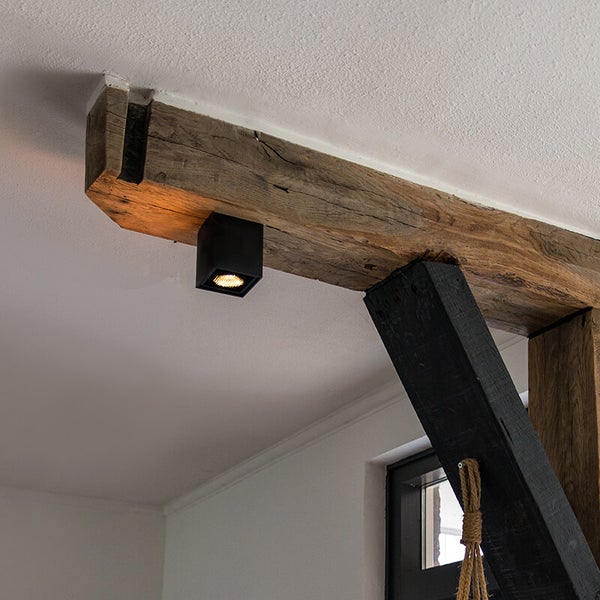 Deckenansicht mit Holzbalken und quadratischer Aufbauleuchte