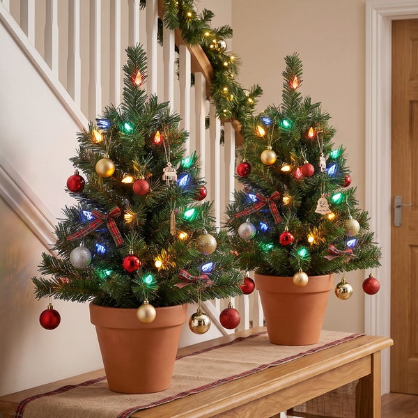 Zwei künstliche Weihnachtsbaumzweige mit integrierter, mehrfarbiger Lichterkette für die weihnachtliche Dekoration.