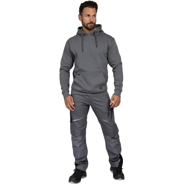 Mann in grauem Kapuzenpullover und grauer Arbeitshose mit Taschen und reflektierenden Elementen sowie schwarzen Arbeitsschuhen.