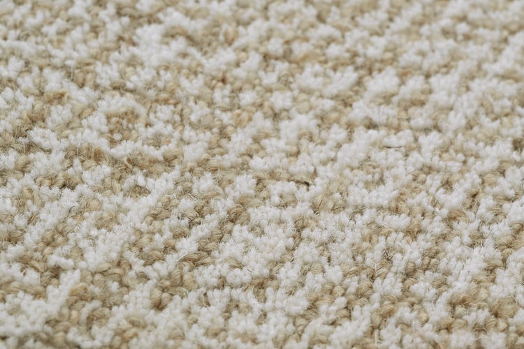 Nahaufnahme einer Hochflor-Teppichoberfläche mit gemusterter Struktur.