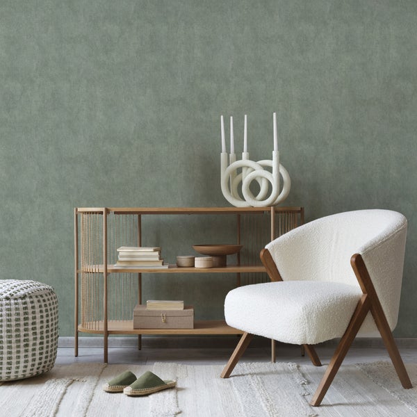 Wohnzimmer mit Bücherregal, Sessel, Hocker, Teppich und Dekoration