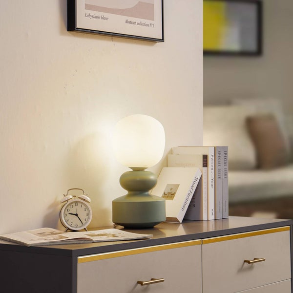 Nachttisch mit Lampe, Wecker und Büchern als Dekoration