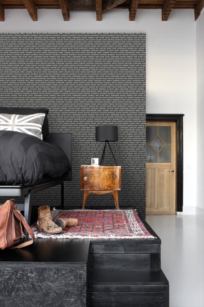 Schlafzimmer mit Bett, Nachttisch, Lampe und dekorativer Wandtapete