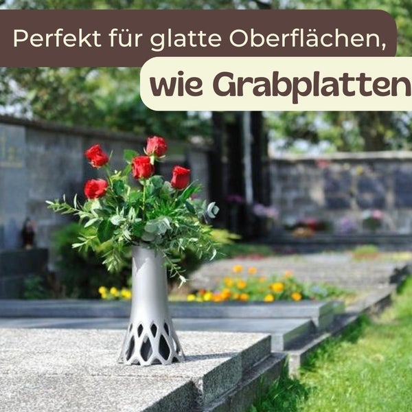 Silberfarbene Blumenvase mit roten Rosen auf einem Grabstein