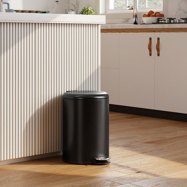 Moderner schwarzer Treteimer in einer hellen, organisierten Küche mit Lamelleninsel und Holzfußboden.