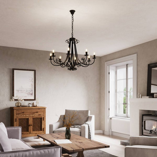 Wohnzimmer mit Kamin, Kommode, Couchtisch und schwarzem Kronleuchter