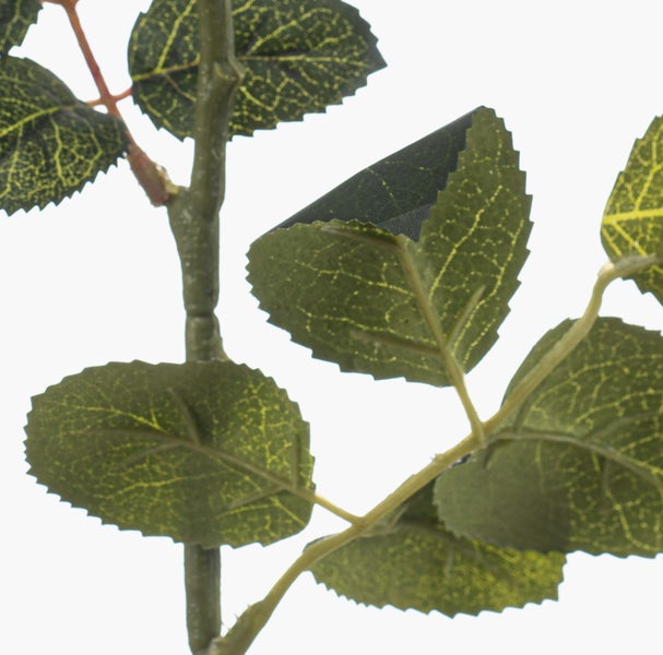 Detailaufnahme von künstlichen grünen Blättern an einem Zweig aus Kunststoff für Dekoration.