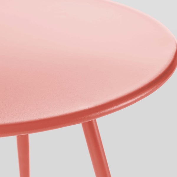 Nahaufnahme einer runden Tischplatte aus Metall in Koralle.