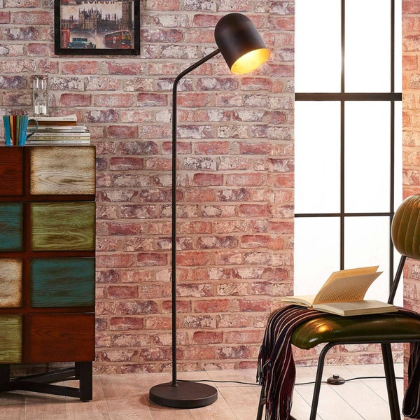 Stehleuchte im Raum mit Kommode und Stuhl.