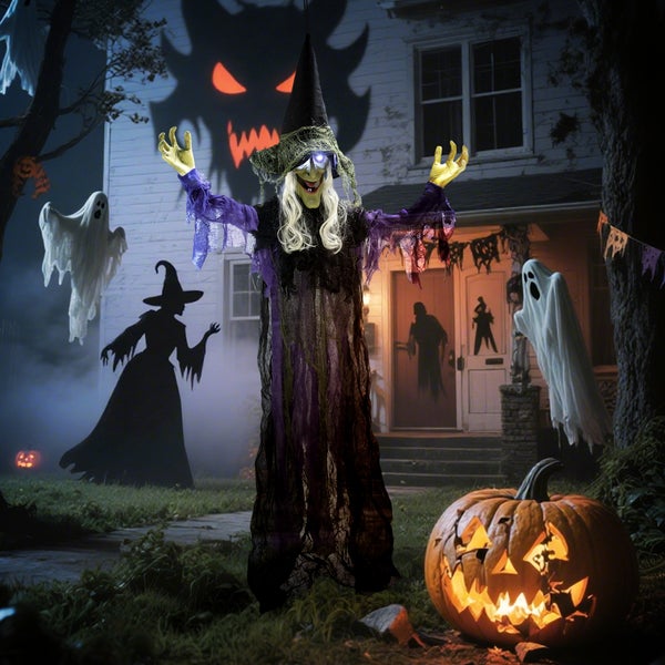 Halloween-Dekoration mit Hexe, Geistern und Kürbissen vor einem Haus.