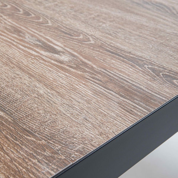 Detailaufnahme einer Tischplatte mit Holzdekor und dunkler Kante.