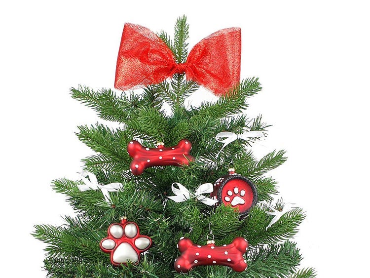 Weihnachtsbaumspitze in Form einer Schleife und Hundemotiv Christbaumschmuck aus Kunststoff an einem künstlichen Weihnachtsbaum