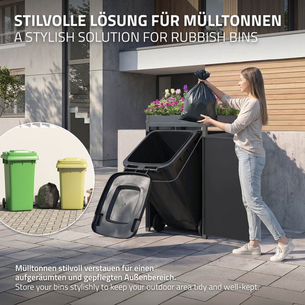 Mülltonnenbox aus Metall mit integriertem Pflanzdach und einer geneigten schwarzen Mülltonne in einem gepflasterten Außenbereich.