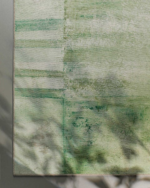 Flachgewebe-Teppich mit abstraktem Vintage-Muster in Grün und Beige.