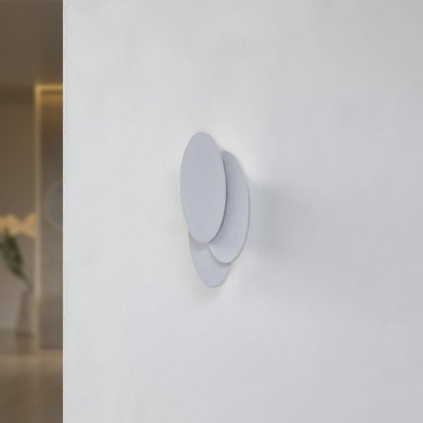 Moderne Wandleuchte mit drei überlappenden runden Scheiben im minimalistischen Design an einer Wand montiert.