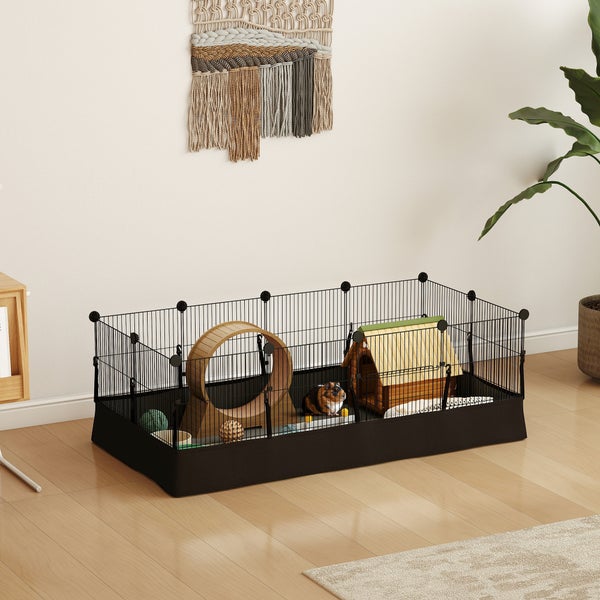 Geräumiges Kleintiergehege für den Innenbereich aus schwarzem Metallgitter mit Holzhaus, Laufrad und Meerschweinchen auf hellem Holzboden.