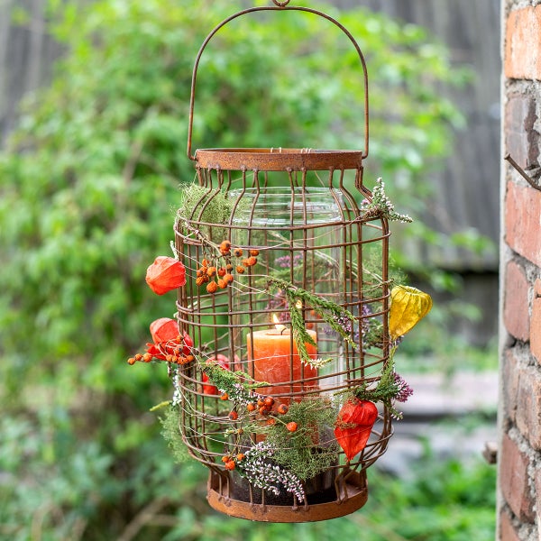 Dekorative Laterne mit Kerze, Blumen und Beeren