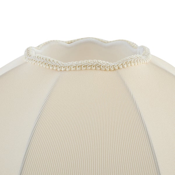 Nahaufnahme eines cremefarbenen Stoff-Lampenschirms mit gewelltem Rand und dekorativer Flechtborte.