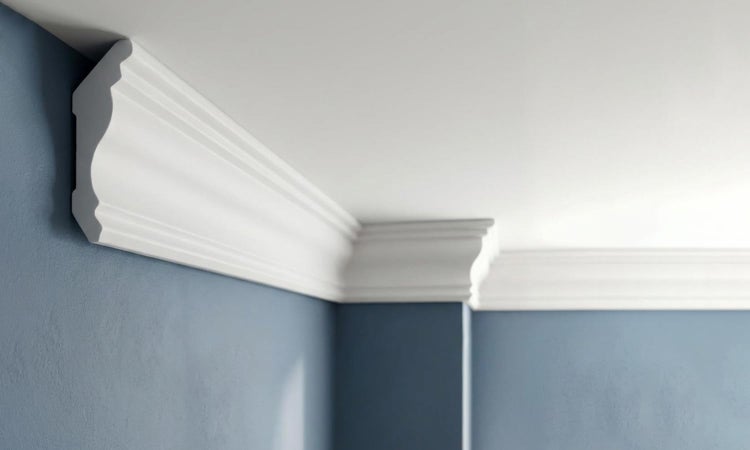 Eckansicht eines Raumes mit angebrachten, weißen Zierleisten