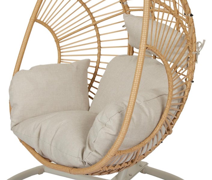 Hängesessel in Eiform mit Geflecht aus Rattan und beigefarbenen Kissen für Garten oder Terrasse.