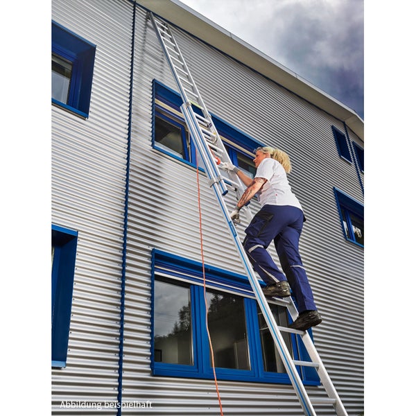 Eine Handwerkerin steigt eine lange Aluminium Mehrzweckleiter an einer modernen Fassade mit Wellblechverkleidung hoch.
