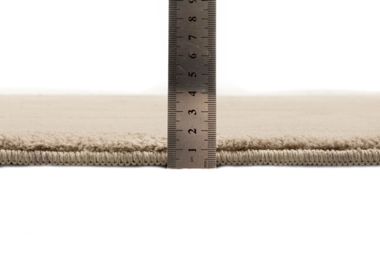 Messung der Florhöhe eines Teppichs mit einem Lineal, circa 1,5 Zentimeter.