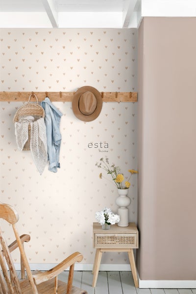 Dekoratives Zimmer mit Herzen Tapete, Kleiderhaken mit Accessoires und einem kleinen Tisch mit Blumenvasen.