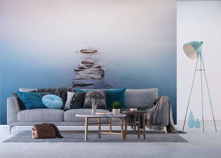 Wohnzimmer mit Sofa, Tisch, Stehlampe und Fototapete mit Steinweg im Wasser