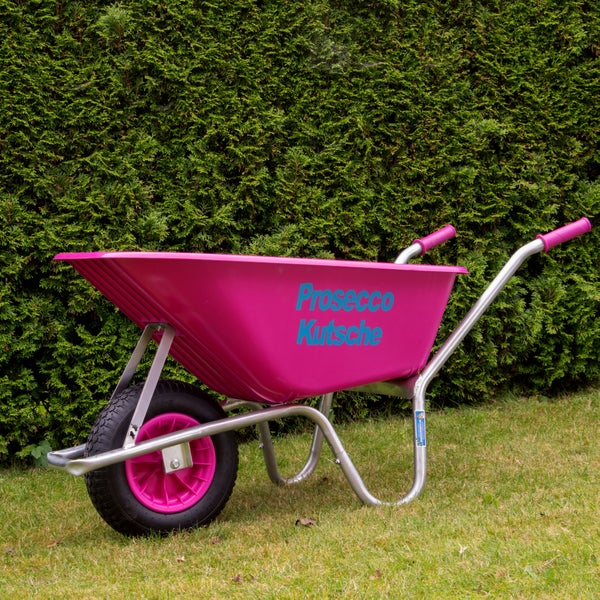 Schubkarre mit Mulde aus Kunststoff und Metallrahmen vor einer Hecke auf Rasen.