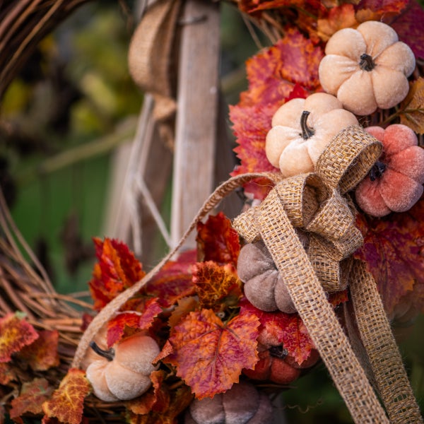 Herbstlicher Türkranz mit Kürbissen, Blättern und Schleife als Dekoration